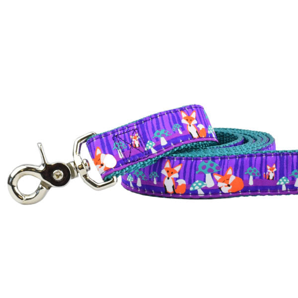 Close-up of dog leash with silver hardware featuring fox and mushroom forest pattern on purple ribbon and teal webbing by 2 Hounds Design