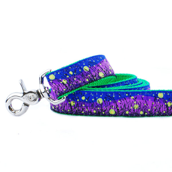 Close-up of dog leash with glowing fireflies over a nighttime field – purple and blue leash with green lining by 2 Hounds Design